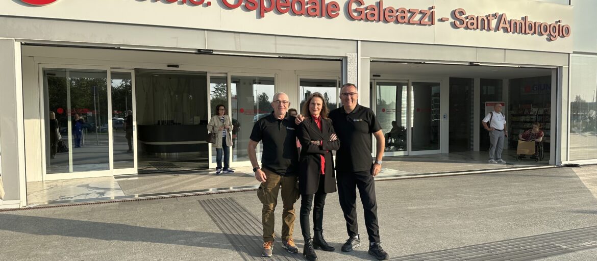 Foto di tre persone in piedi davanti all'ingresso dell'ospedale Galeazzi - Sant'Ambrogio