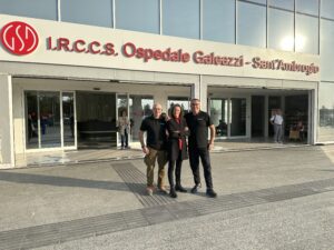 Foto di tre persone in piedi davanti all'ingresso dell'ospedale Galeazzi - Sant'Ambrogio